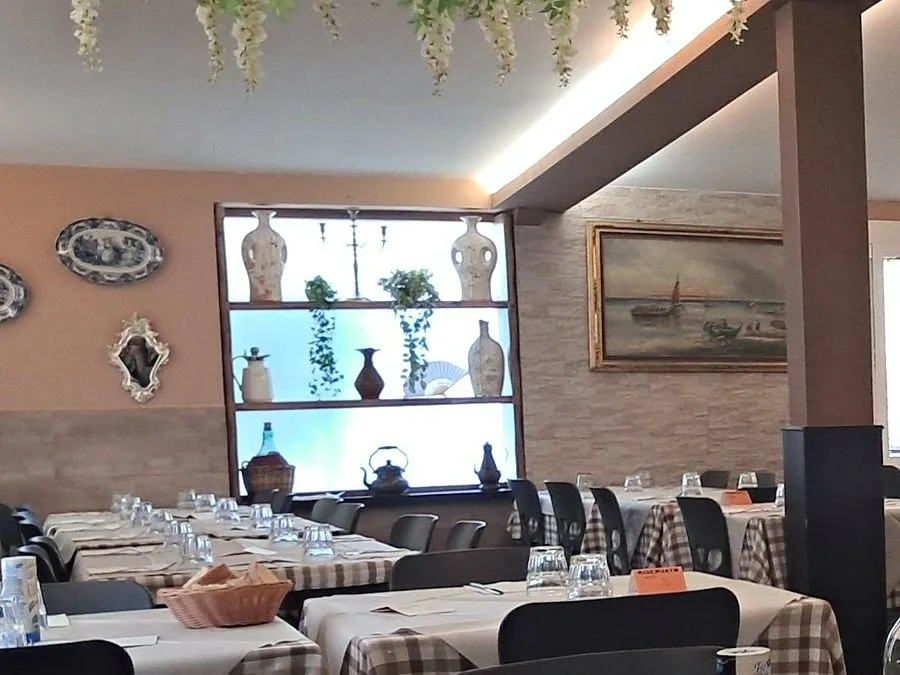 Un angolo della sala: la nicchia con le brocche, i piatti alla parete e il quadro dei battelli